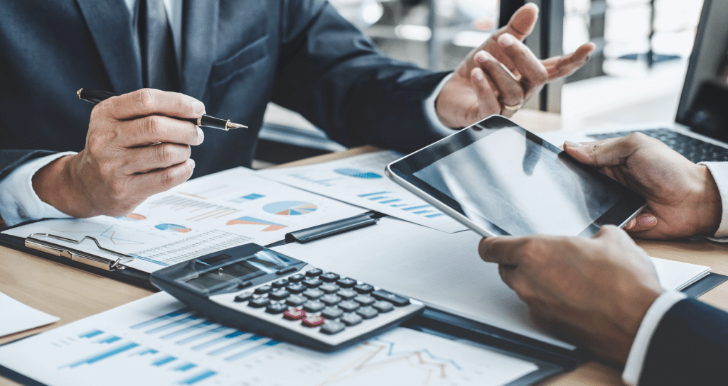 Two men working over financial charts.